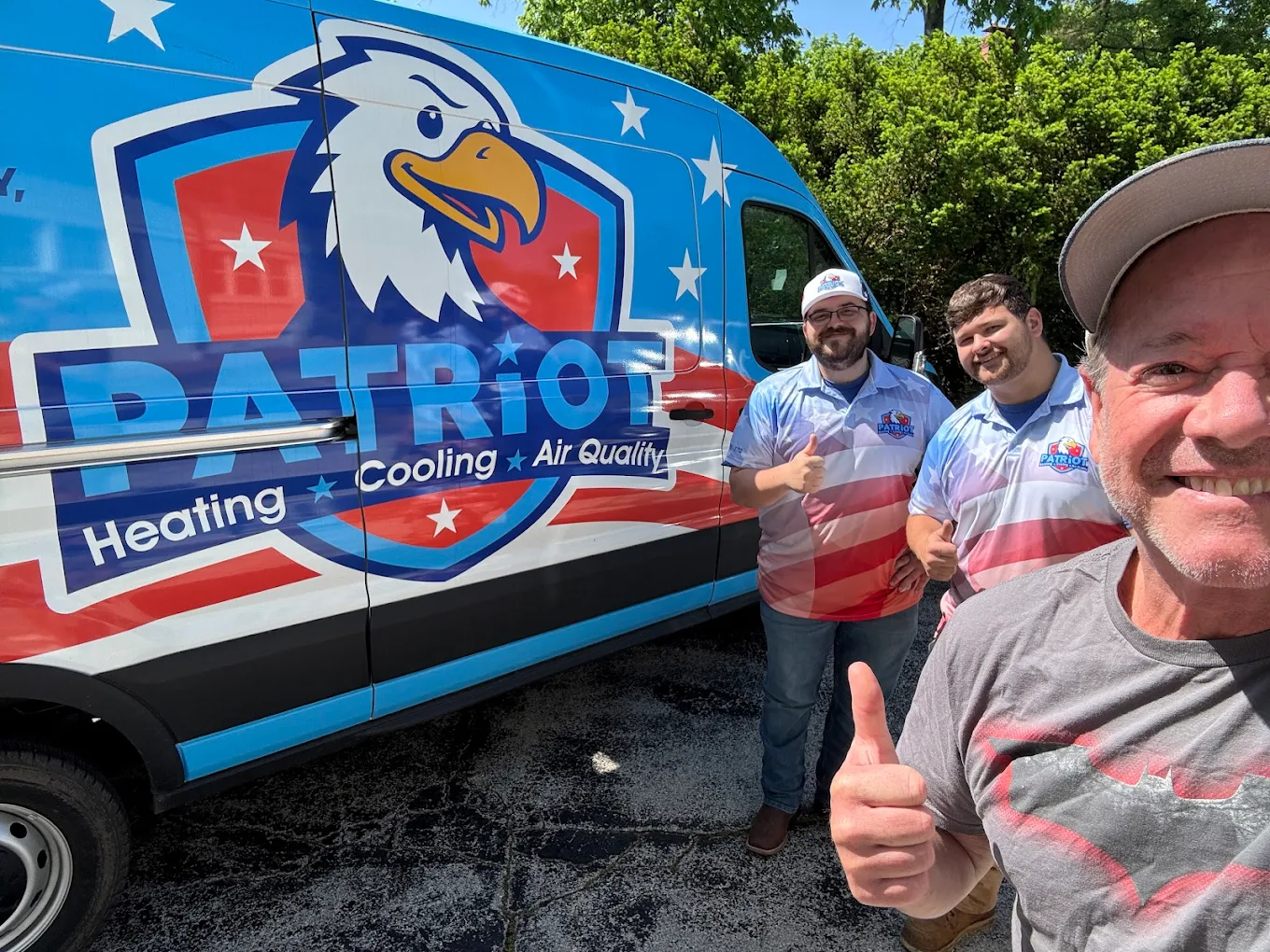 The Patriot Heating, Cooling & Air Quality team giving a thumbs up in front of their branded service van