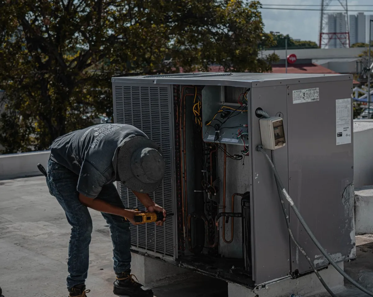 Technician removing the panels from a rooftop air conditioning unit
