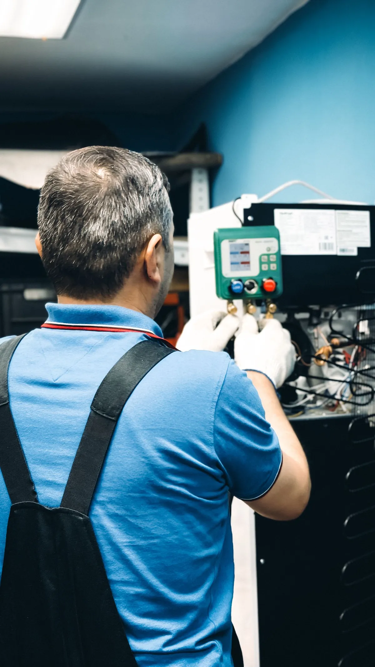 Technician working at the control panel of an indoor air conditioning system