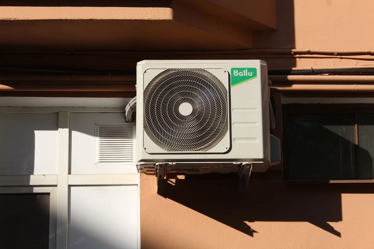 A ductless system's outdoor condenser mounted on a building wall