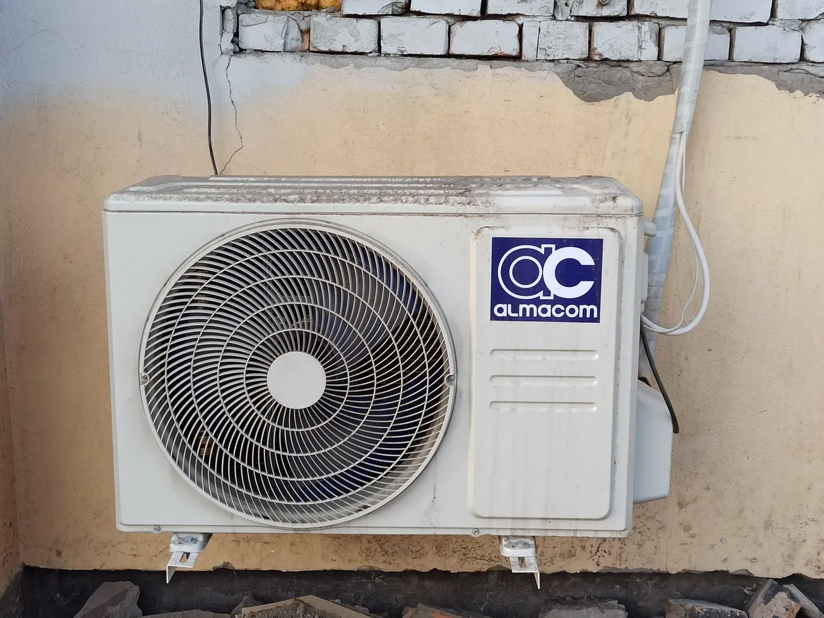 Outdoor condenser unit of a ductless system fixed to a brick wall